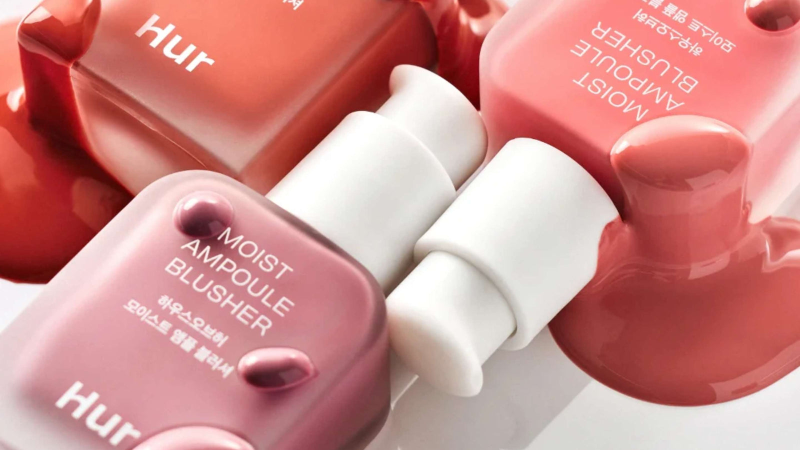Bilden visar två hjärtformade behållare från märket lilybyred, en i en mörkare röd nyans och en i en ljusare rosa ton. Designen är lekfull och romantisk, vilket antyder att produkterna inuti kanske är makeupartiklar som rouge eller highlighters.