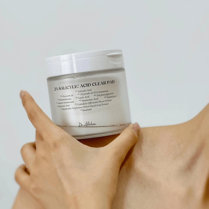 Dr. Althea 2% Salicylic Acid Clear Pad se držijo v roki. Tonik blazinice z 2% salicilne kisline, ki nežno eksfolirajo, pomirjajo kožo in izboljšujejo strukturo kože.
