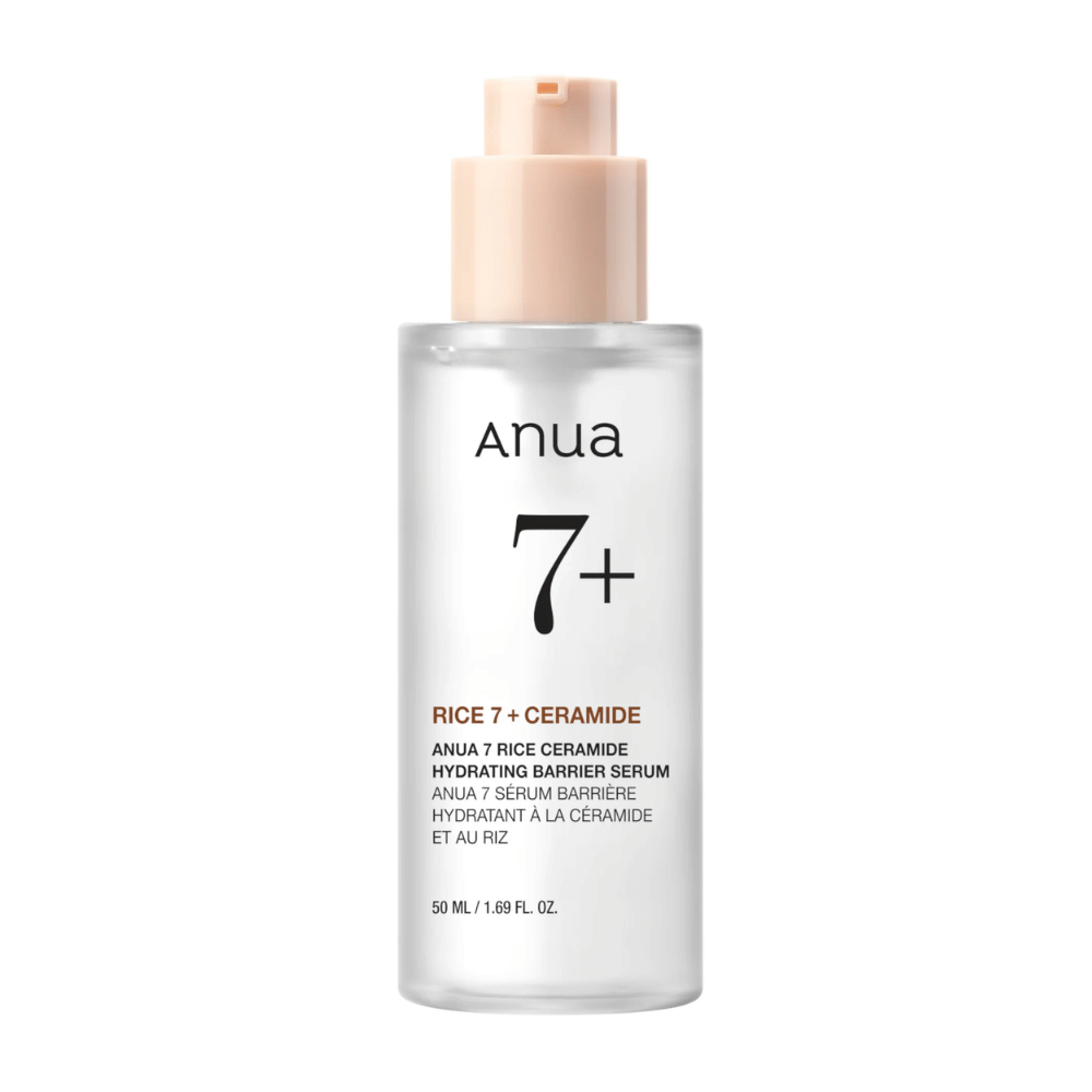 Steklenička "Anua 7+ Rice Ceramide Hydrating Barrier Serum" s čisto in minimalistično zasnovo. Embalaža je prozorna s svetlo roza črpalko in vsebuje 50 ml seruma, ki je obogaten z rižem in ceramidi za vlaženje in krepitev kožne pregrade.