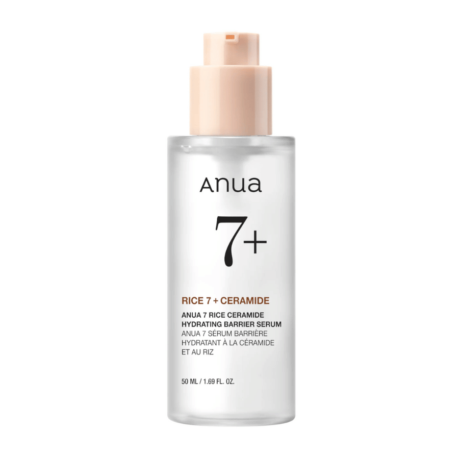 Steklenička "Anua 7+ Rice Ceramide Hydrating Barrier Serum" s čisto in minimalistično zasnovo. Embalaža je prozorna s svetlo roza črpalko in vsebuje 50 ml seruma, ki je obogaten z rižem in ceramidi za vlaženje in krepitev kožne pregrade.
