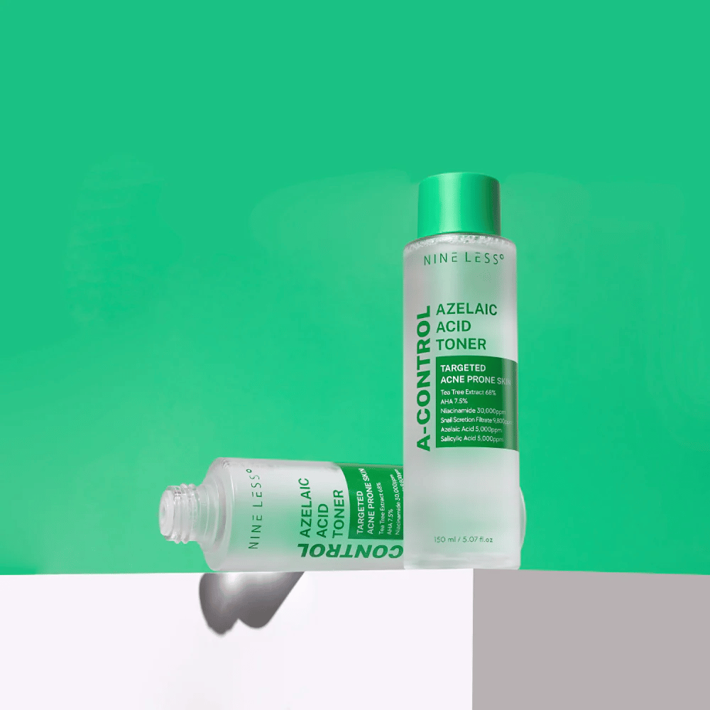 Dve steklenički Nine Less A-Control Azelaic Acid Toner postavljeni na zelenem ozadju, ena stoji, druga leži.