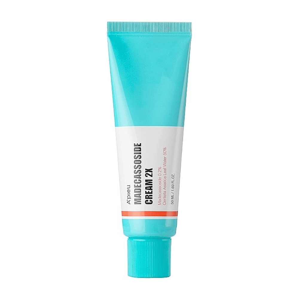 Tuba z A'PIEU Madecassoside Cream 2X, z svetlo turkizno barvo na vrhu, ki prehaja v belo proti dnu. Tuba ima jasno besedilo, ki navaja znamko in ime izdelka ter aktivno sestavino Madecassoside 2%. Oranžna barvna akcentna črta obkroža tubo. Izdelek se zdi kot krema za kožo, usmerjena v nego in obnovo kože. Ozadje je nevtralno, da ohrani fokus na izdelku.