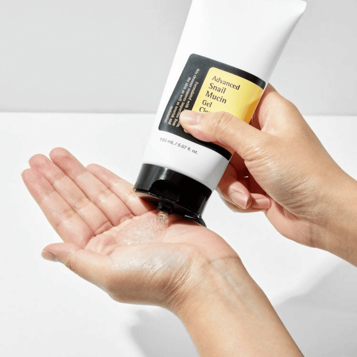 Roka nanaša COSRX Advanced Snail Mucin Gel Cleanser – nežno gel čistilo s polžjo sluzjo, ki globinsko čisti in ohranja ravnovesje vlage v koži.