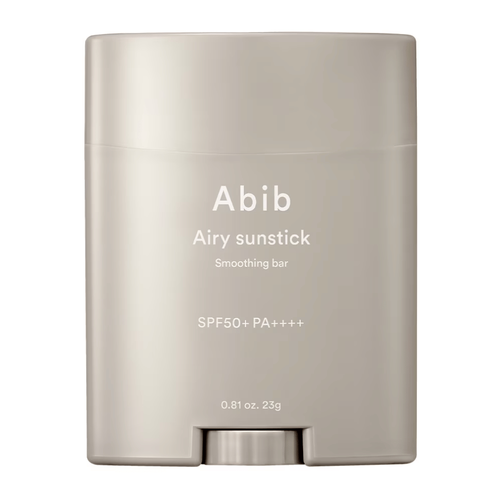 Slika prikazuje bež zaščitno palčko za sončenje znamke Abib z napisom "Airy Sunstick Smoothing Bar" in zaščitnim faktorjem SPF50+ PA++++, popolno za dnevno zaščito pred UV-žarki.