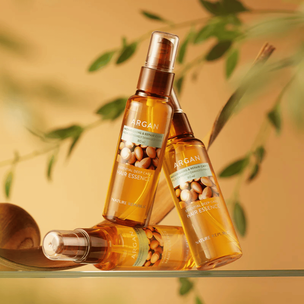 Tri stekleničke Nature Republic Argan Essential Moisture Hair Oil z arganovim oljem – nudi hranilnost, sijaj in popravlja poškodovane lase.