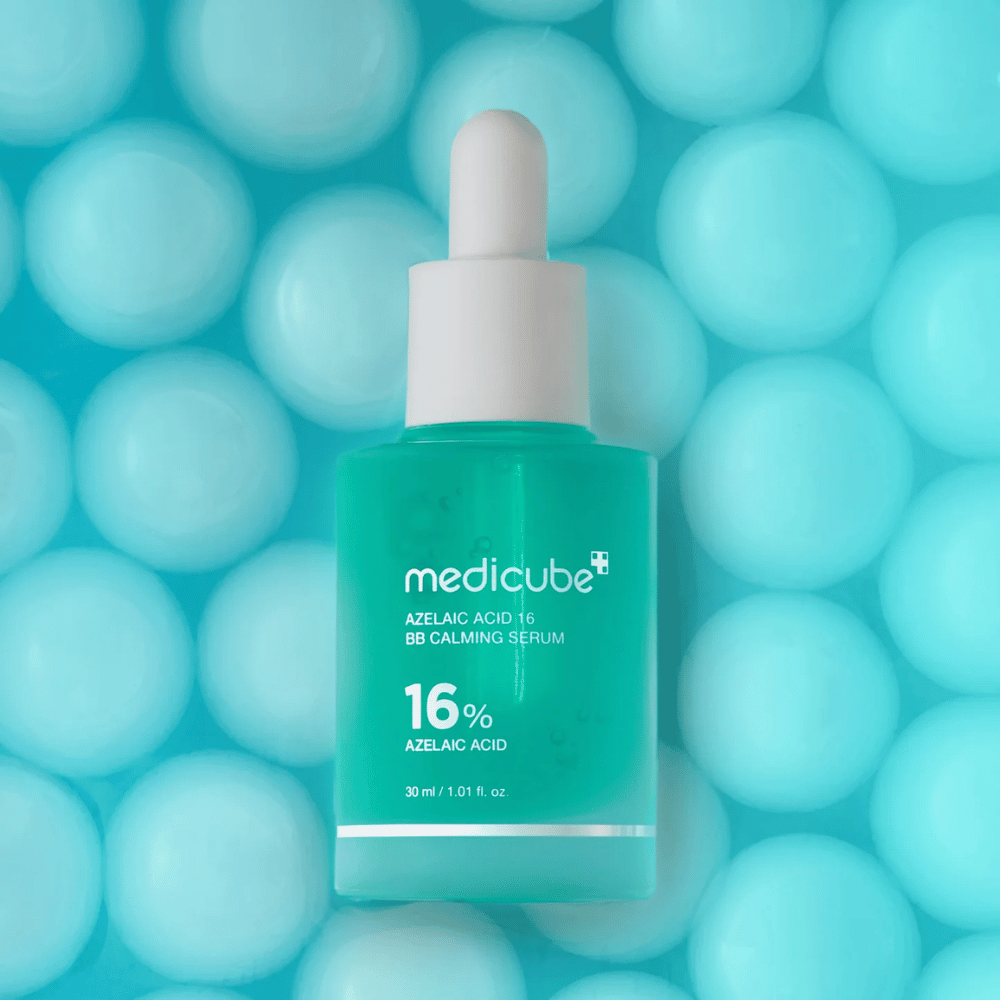 Promocijska slika Medicube Azelaic Acid 16 BB Calming Serum na turkiznem ozadju z mehkimi sferami, ki simbolizirajo vlaženje, pomirjujoč učinek in enakomerno teksturo kože.