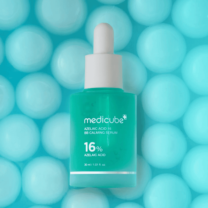 Promocijska slika Medicube Azelaic Acid 16 BB Calming Serum na turkiznem ozadju z mehkimi sferami, ki simbolizirajo vlaženje, pomirjujoč učinek in enakomerno teksturo kože.