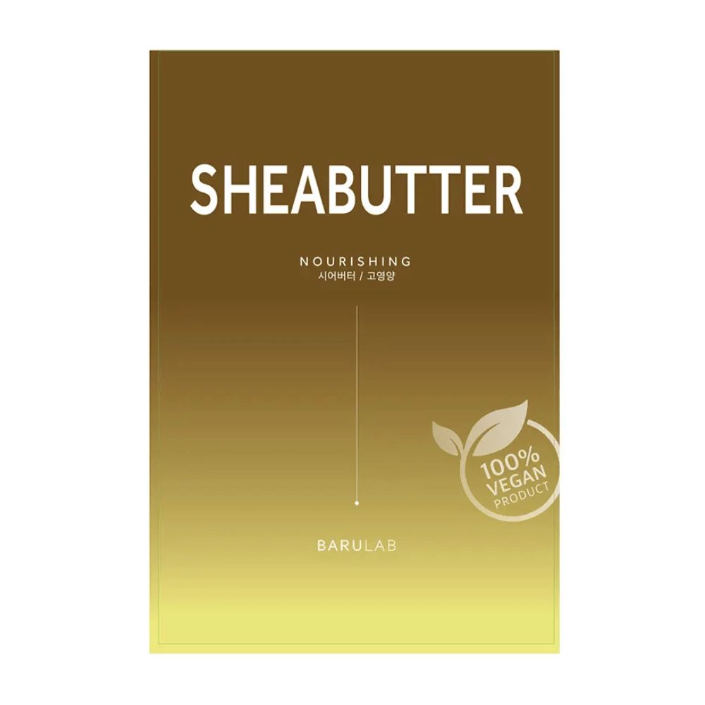 Embalaža maske BARULAB "SHEABUTTER Nourishing", označena kot "100% Vegan Product". Embalaža ima barvni prehod, ki prehaja iz temno zlato rjave na vrhu v svetlo rumeno na dnu.