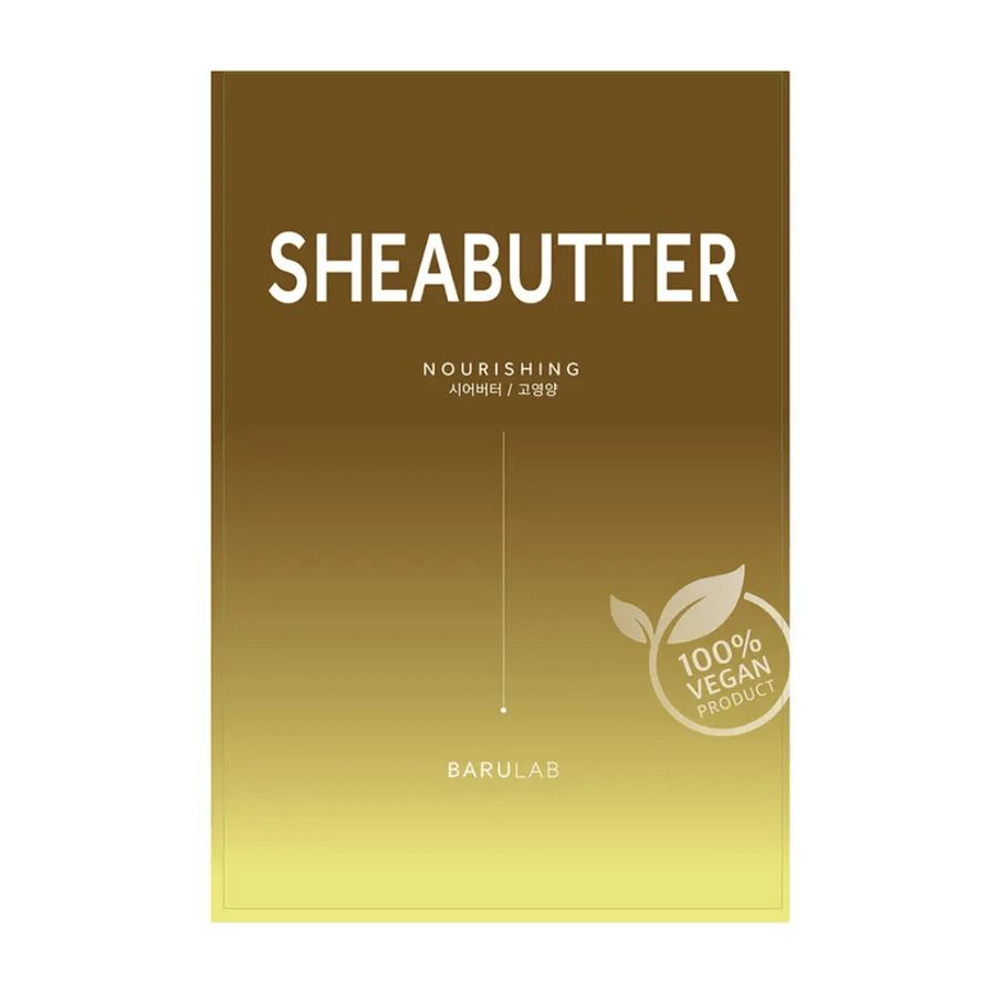 Embalaža maske BARULAB "SHEABUTTER Nourishing", označena kot "100% Vegan Product". Embalaža ima barvni prehod, ki prehaja iz temno zlato rjave na vrhu v svetlo rumeno na dnu.