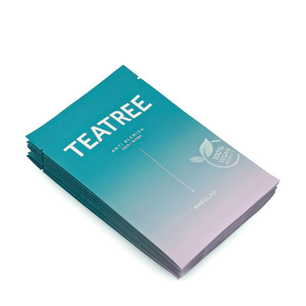 Kup pakiranj mask BARULAB "TEATREE Anti Blemish", vse označene kot "100% veganski izdelek". Pakiranja imajo enotno turkizno barvo.
