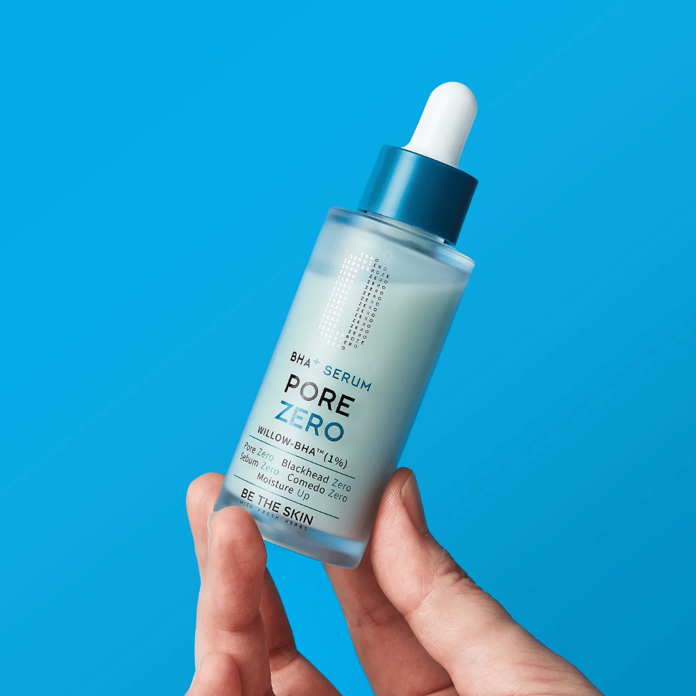 Be The Skin BHA+ Pore Zero Serum v roki na modrem ozadju