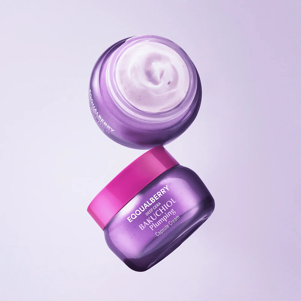 Dve odprti posodici EQQUALBERRY Bakuchiol Plumping Capsule Cream v vijolični embalaži z roza pokrovom. Mehka tekstura kreme je jasno vidna od zgoraj.