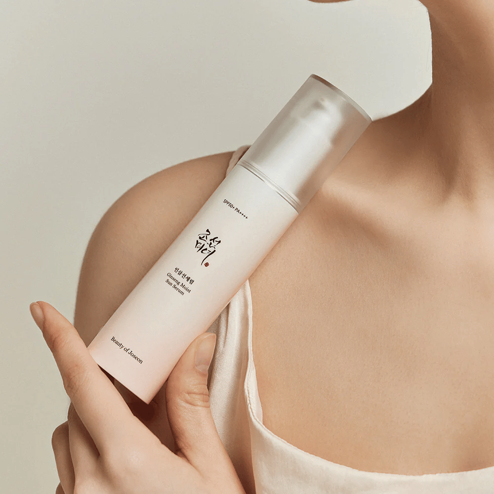 Ženska, ki drži steklenico Beauty of Joseon's Ginseng Moist Sun Serum SPF 50+ PA++++, ki nudi zaščito SPF 50+ PA++++ in prednosti za nego kože.