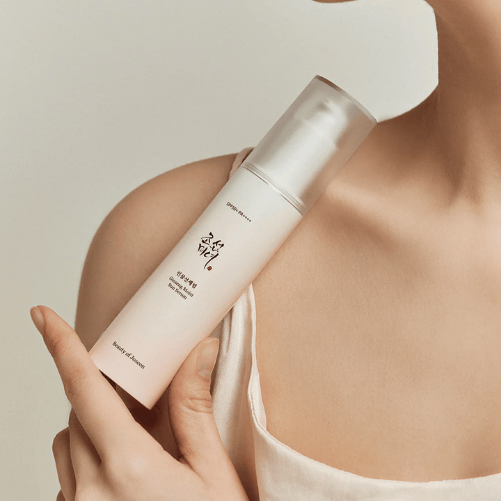 Ženska, ki drži steklenico Beauty of Joseon's Ginseng Moist Sun Serum SPF 50+ PA++++, ki nudi zaščito SPF 50+ PA++++ in prednosti za nego kože.