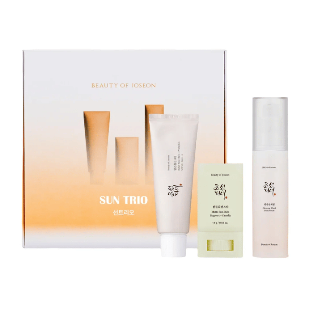 Beauty of Joseon - Sun Trio darilni set s tremi izdelki za zaščito pred soncem: Relief Sun Rice + Probiotics, Matte Sun Stick Mugwort + Camellia in Ginseng Moist Sun Serum pred gradientno embalažo v beli in oranžni barvi.