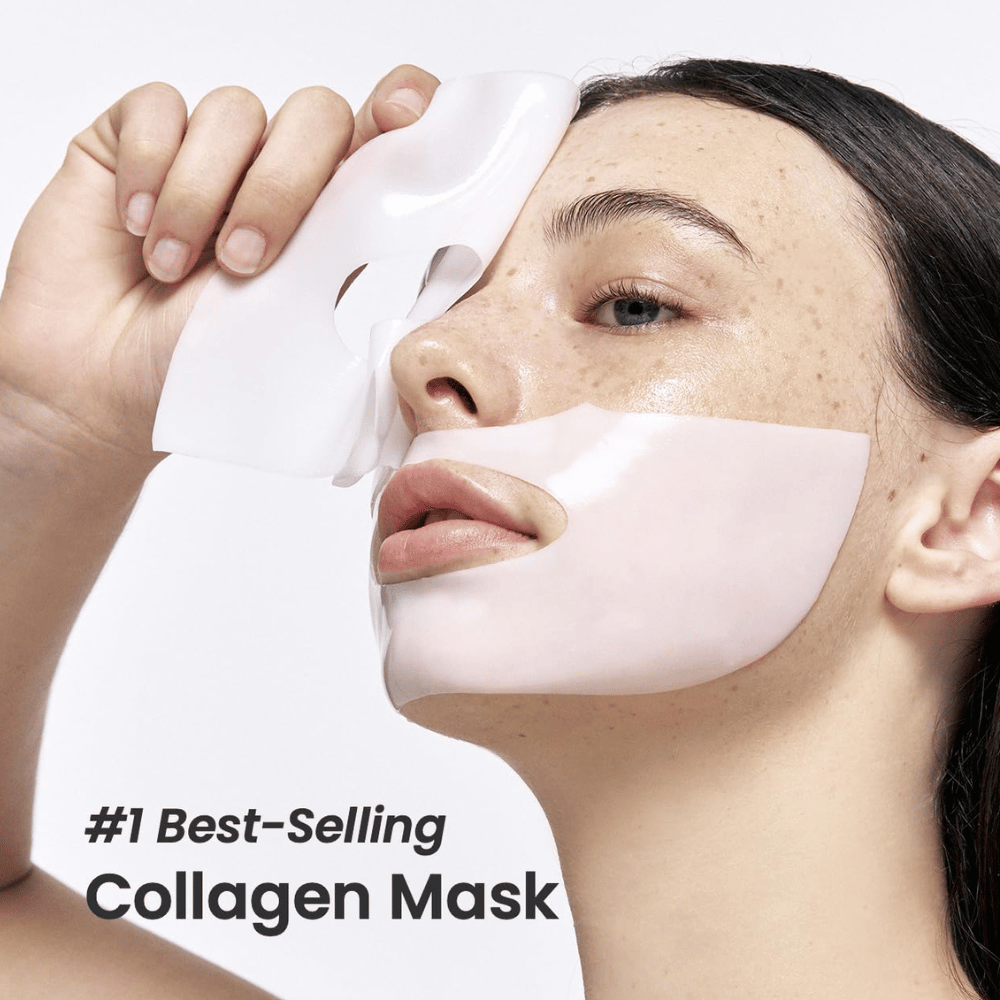Slika prikazuje mlado žensko, ki nanaša Bio-Collagen Real Deep Mask iz Biodance, obrazno masko, ki je označena kot "#1 Best-Selling Collagen Mask". Maska je bela in pokriva njena lica in usta, kar poudarja njeno priljubljenost in učinkovitost za nego kože.