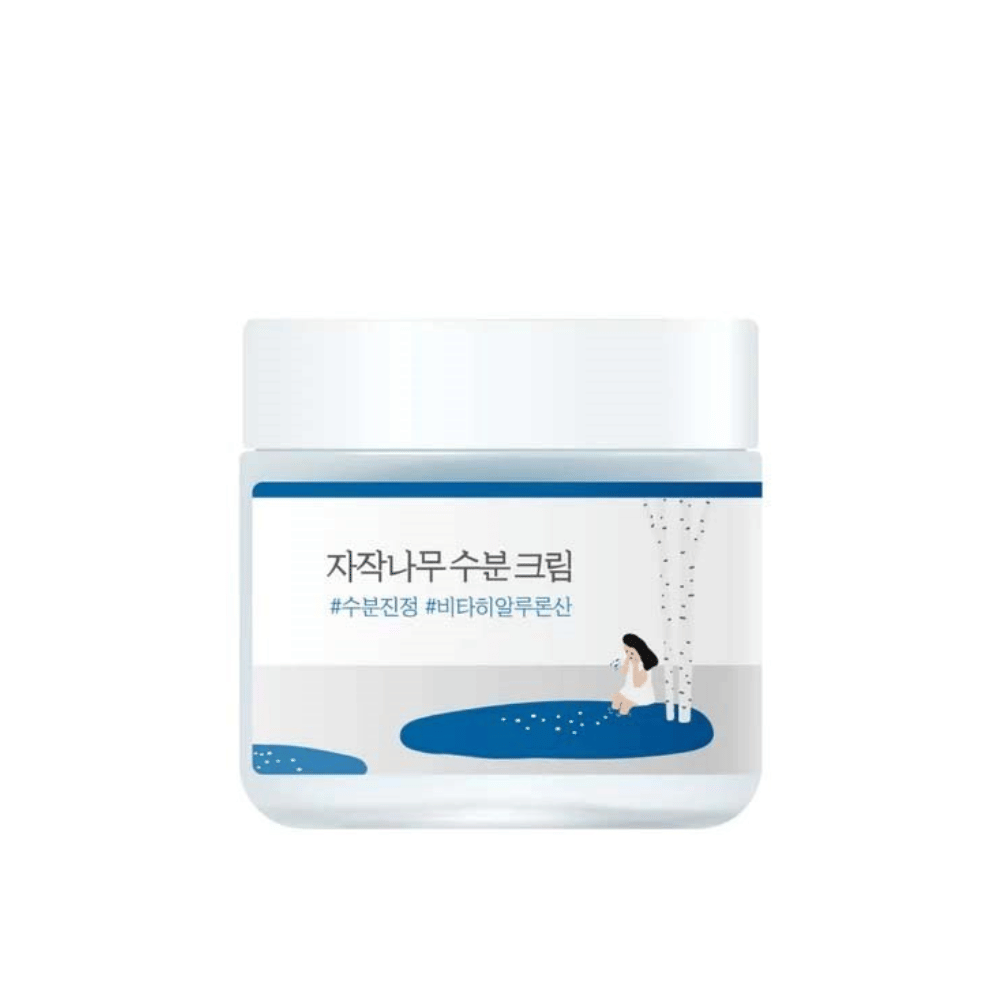 Round Lab Birch Juice Moisturizing Cream v prozorni posodi z belim pokrovom in modro etiketo z ilustracijo breze in dekleta, na beli podlagi.