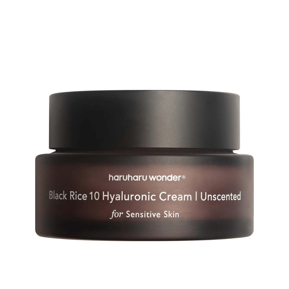 Slika prikazuje kozarec kreme za kožo znamke haruharu wonder. Izdelek se imenuje "Black Rice 10 Hyaluronic Cream" in je posebej zasnovan za občutljivo kožo, kar je razvidno iz besedila.