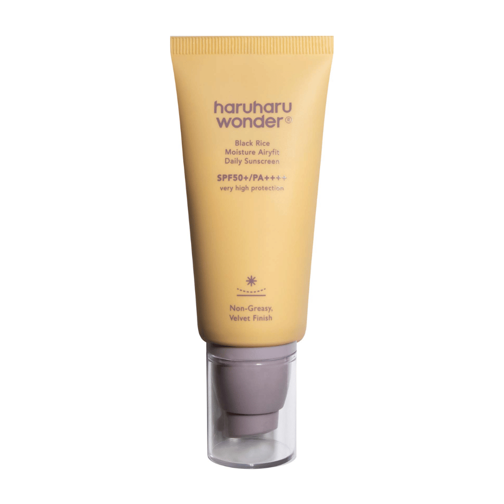 Rumena tuba z Haruharu Wonder Black Rice Moisture Airyfit Daily Sunscreen SPF 50+ PA++++. Tuba ima prozoren pokrovček in besedilo, ki opisuje visoko zaščitno raven kreme za sončenje ter njeno nemastno, žametno gladko končno obdelavo.