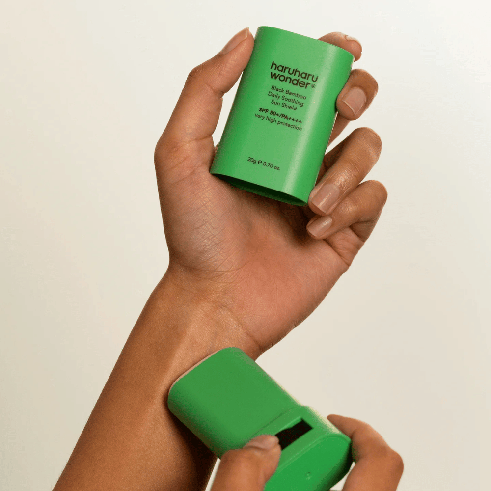 Oseba nanese Haruharu Wonder Black Bamboo Daily Soothing Sun Shield – zeleni zaščitni stik s SPF 50+ PA++++ – na zapestje.