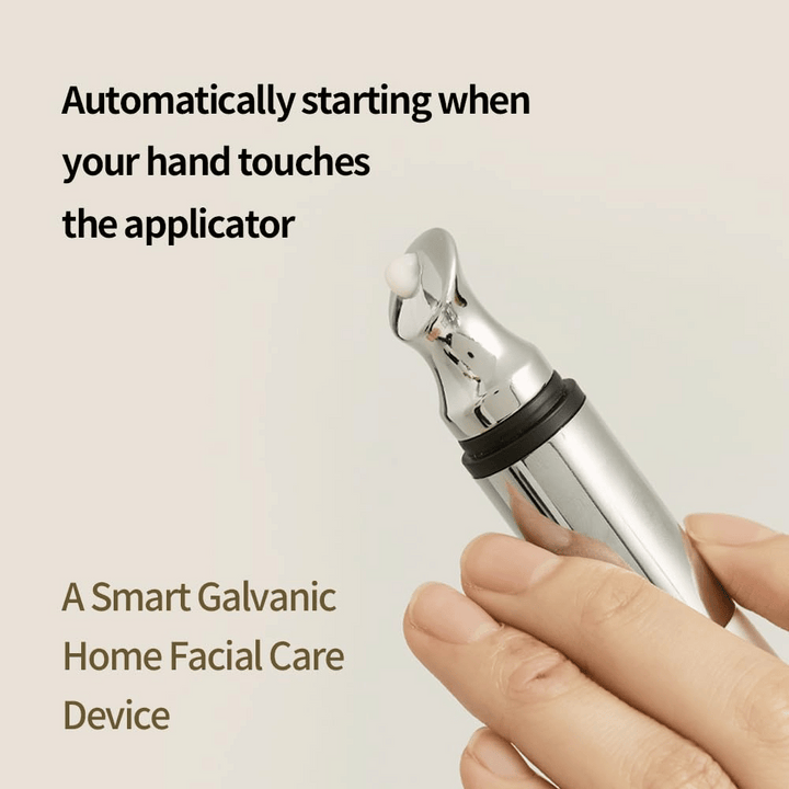 Povečava roke, ki drži galvanski aplikator za kremo za oči z avtomatsko funkcijo vklopa ob dotiku. Besedilo na sliki opisuje funkcijo in napravo kot pametno domače orodje za nego obraza.