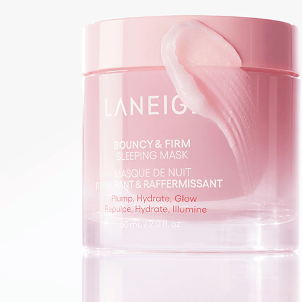 Povečana slika Laneige Bouncy & Firm Sleeping Mask v roza lončku, z delom maske, ki je nanesen na rob pokrovčka. Izdelek je namenjen polnjenju, vlaženju in sijaju. Lonček vsebuje 60 ml in ima napis "Polnjenje, Vlaženje, Sijaj."