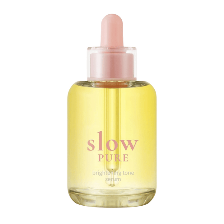 Slow Pure Brightening Tone Serum v prozorni steklenički s pipeto, napolnjeni s sijočim rumenim serumom.