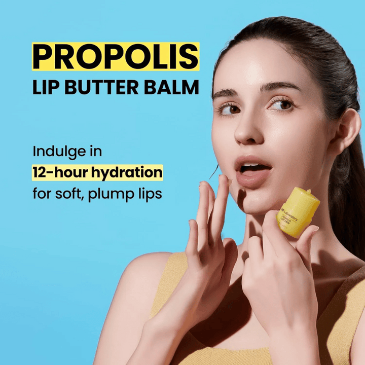 Ženska nanaša CNP Laboratory Propolis Lip Butter Balm, poudarjeno na modrem ozadju. Izdelek obljublja 12 ur vlaženja za mehke in polne ustnice, kar je prikazano z rumeno tubo, ki jo drži v roki.