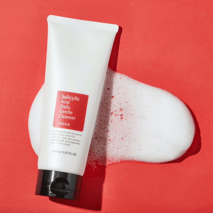 COSRX Salicylic Acid Daily Gentle Cleanser 150ml – učinkovito čistilo za obraz s salicilno kislino proti aknam, ogrcem in nečisti koži, prikazano s peno.