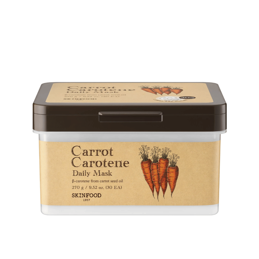 Paket "Carrot Carotene Daily Mask" iz SKINFOOD, ki vsebuje 30 obraznih mask. Izdelek je obogaten z β-karotenom iz olja korenčkovih semen in je zasnovan za vsakodnevno uporabo. Embalaža je robustna z vintage navdihnjeno etiketo, ki poudarja korenje kot glavno sestavino.