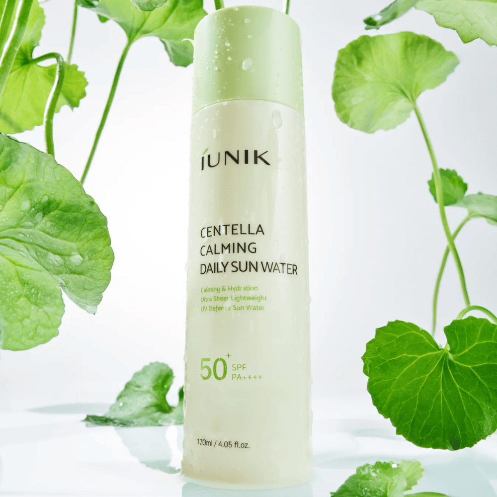 2. iUNIK Centella Calming Daily Sun Water SPF50+ PA++++ – vlažilna zaščita pred soncem s centello asiatica, obdana z zelenimi listi in vodnimi kapljicami