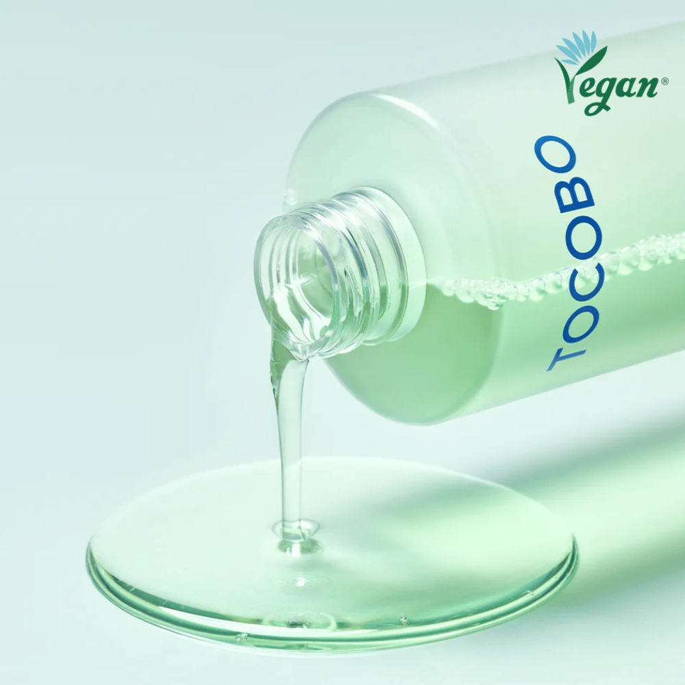 Bližinski posnetek TOCOBO Cica Calming Aqua Toner, ki se izliva, da poudari jasno, lahko in osvežilno teksturo izdelka.