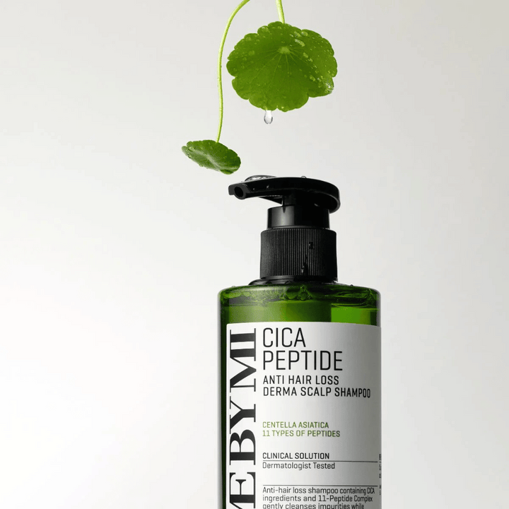 Steklenica SOME BY MI Cica Peptide Anti Hair Loss Derma Scalp Shampoo v zeleni barvi s črno črpalko in belo etiketo, obdana s centela listi in kapljico vode.