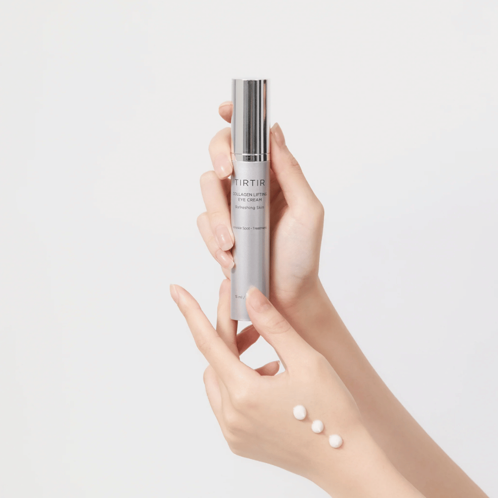 Roke, ki držijo tubo s kremo za oči TIRTIR Collagen Lifting, s stisnjenim izdelkom na hrbtni strani roke.