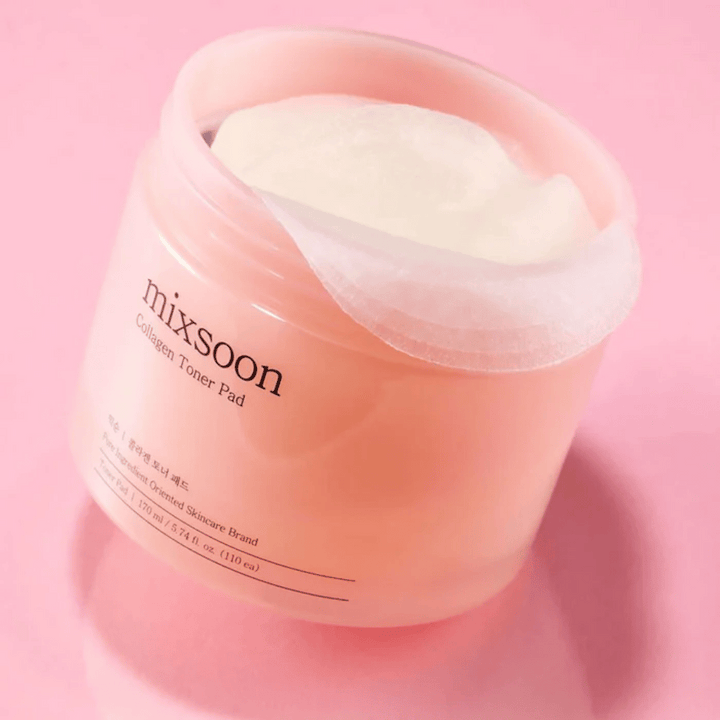 Mixsoon Collagen Toner Pad s 110 blazinicami v roza posodi, fotografiran na roza ozadju.