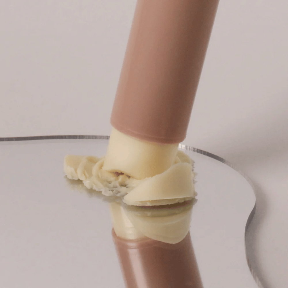 Povečana slika multi balm stika, ki se pritisne na površino s kremasto konsistenco.