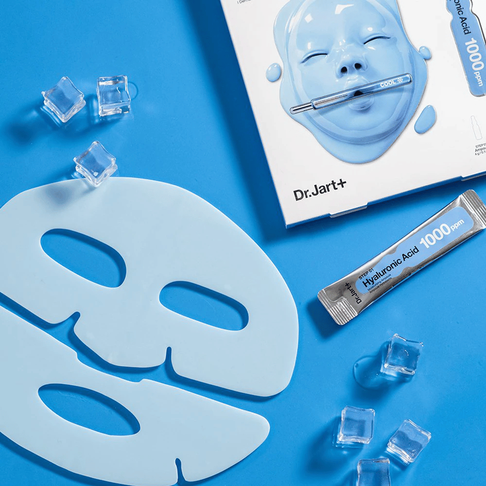 Dr.Jart+ Cryo Rubber Moisturizing Mask z dvodelno modro gumijasto masko, ledenimi kockami, ampulo hialuronske kisline in embalažo na modrem ozadju.