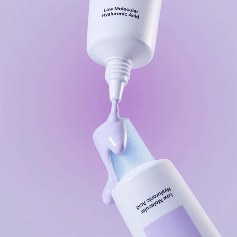 Bližnji posnetek Torriden DIVE IN Tone Up Sun Cream Purple, kjer se vijolična krema nanaša iz tube, da prikaže konsistenco izdelka.