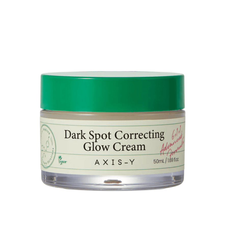 Kozarec "AXIS-Y Dark Spot Correcting Glow Cream". Ta krema je namenjena korekciji temnih madežev in daje koži sijaj. Embalaža je elegantna s prozornim dnom in vpadljivim zelenim pokrovom.