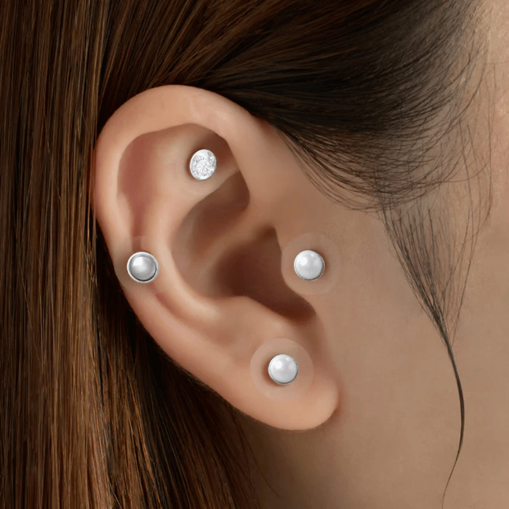 Bližnji posnetek ušesa z več RETURNITY Ear Therapy Acupressure Patch, nameščenimi na različnih delih ušesa za akupresuro in eleganten videz.