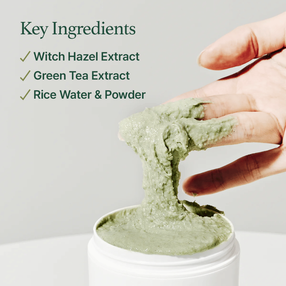 Roka dviguje Arencia Fresh Green Rice Mochi Cleanser iz posode. Zelena, viskozna krema se razteza med prsti. Besedilo navaja sestavine: Hamamelis, Zeleni Čaj, Riževa Voda & Prašek.