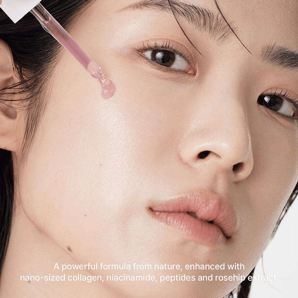 Bližnji posnetek obraza, kjer se Arencia Red Smoothie Serum 8 nanaša s pipeto. Serum ima rahlo roza odtenek in vsebuje nano-kolagen, niacinamid, peptide in izvleček šipka.