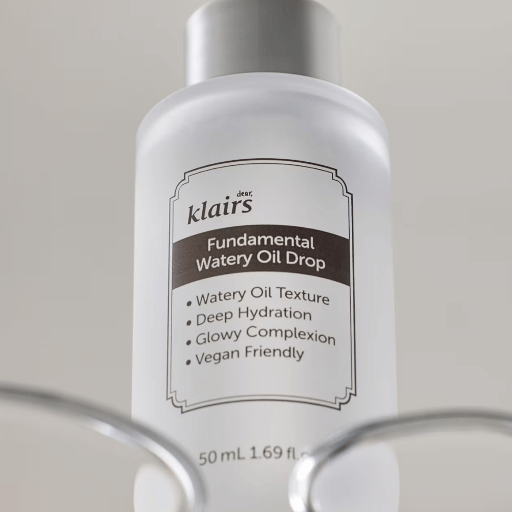 Steklenička Klairs Fundamental Watery Oil Drop, 50 ml, postavljena v prozornem držalu, z jasno etiketo, ki poudarja vlažilne in veganske lastnosti izdelka.