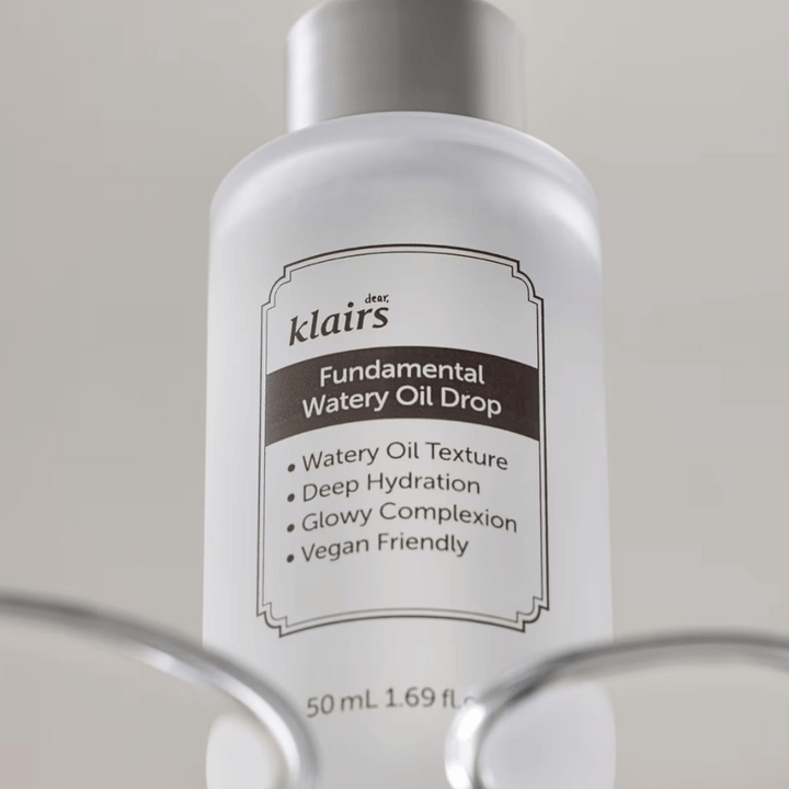 Steklenička Klairs Fundamental Watery Oil Drop, 50 ml, postavljena v prozornem držalu, z jasno etiketo, ki poudarja vlažilne in veganske lastnosti izdelka.
