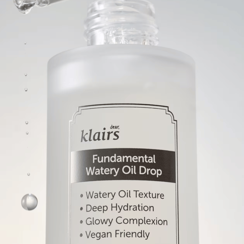 Povečava stekleničke Klairs Fundamental Watery Oil Drop, z besedilom, ki poudarja lastnosti izdelka kot so "Watery Oil Texture", "Deep Hydration", "Glowy Complexion" in "Vegan Friendly".
