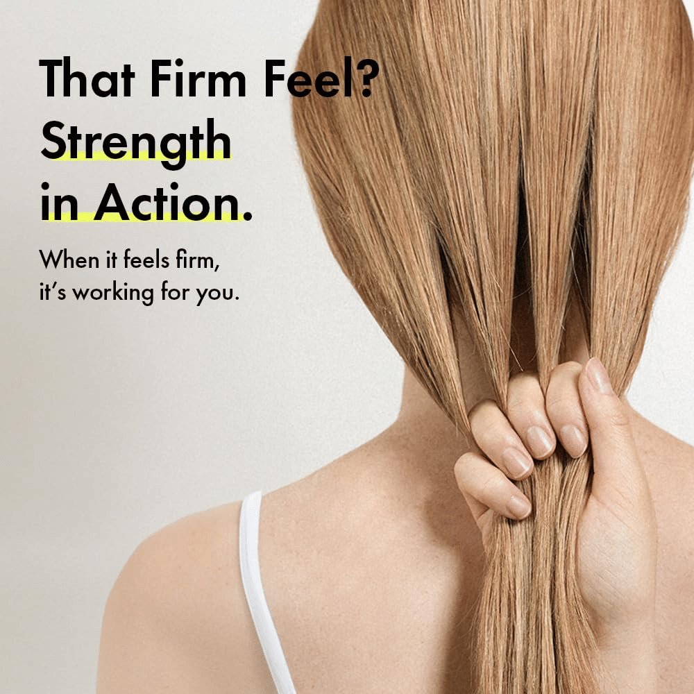 Oseba drži svoje lase, da ponazori močnejša lasna vlakna in čvrstejši občutek las po uporabi Grabity g0.0 Hair Lifting Shampoo Strong.