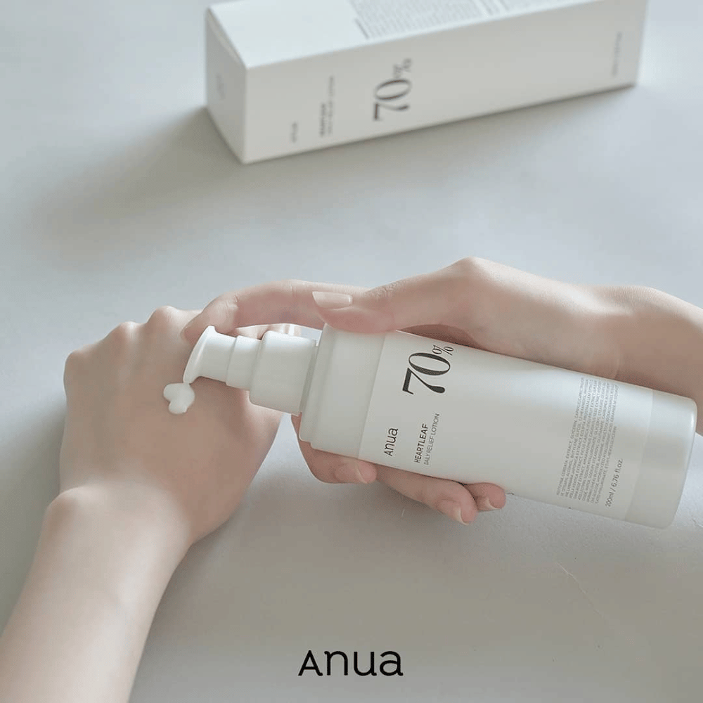 Oseba drži steklenico Anua Heartleaf 70% Daily Lotion 200ml.