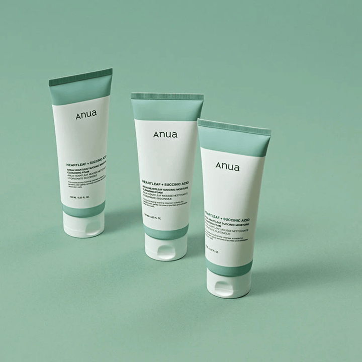 Tri embalaže Anua Heartleaf + Succinic Acid Moisture Cleansing Foam, predstavljene na svetlo zelenem ozadju. Slika poudarja čist in minimalističen dizajn izdelka ter daje profesionalen vtis serije izdelkov.