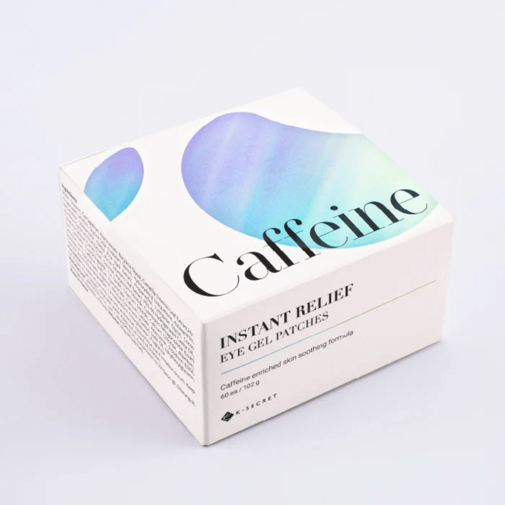 Embalaža K-Secret Instant Relief Eye Gel Patches s kofeinom v beli zasnovi z modrimi in zelenimi toni.
