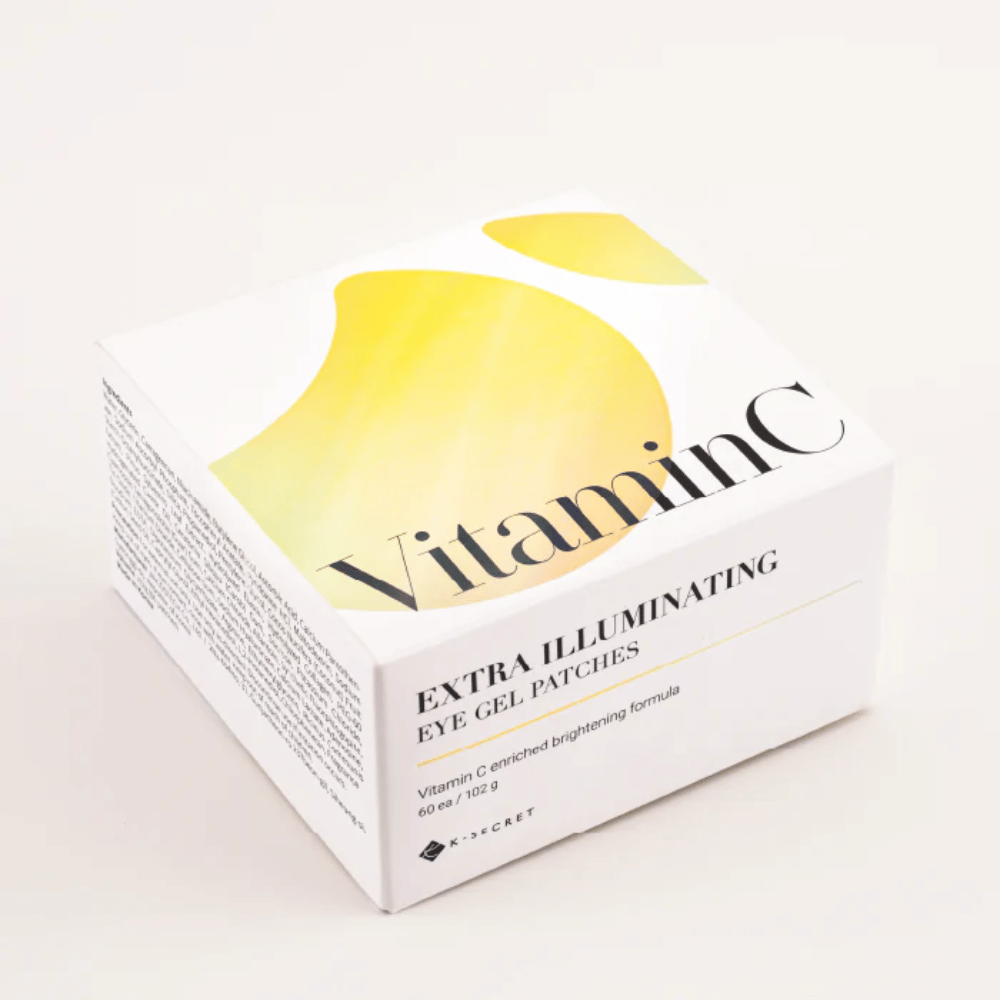 Embalaža K-Secret Extra Illuminating Eye Gel Patches z vitaminom C v beli in rumeni zasnovi.